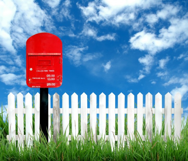 red postbox with white fence
